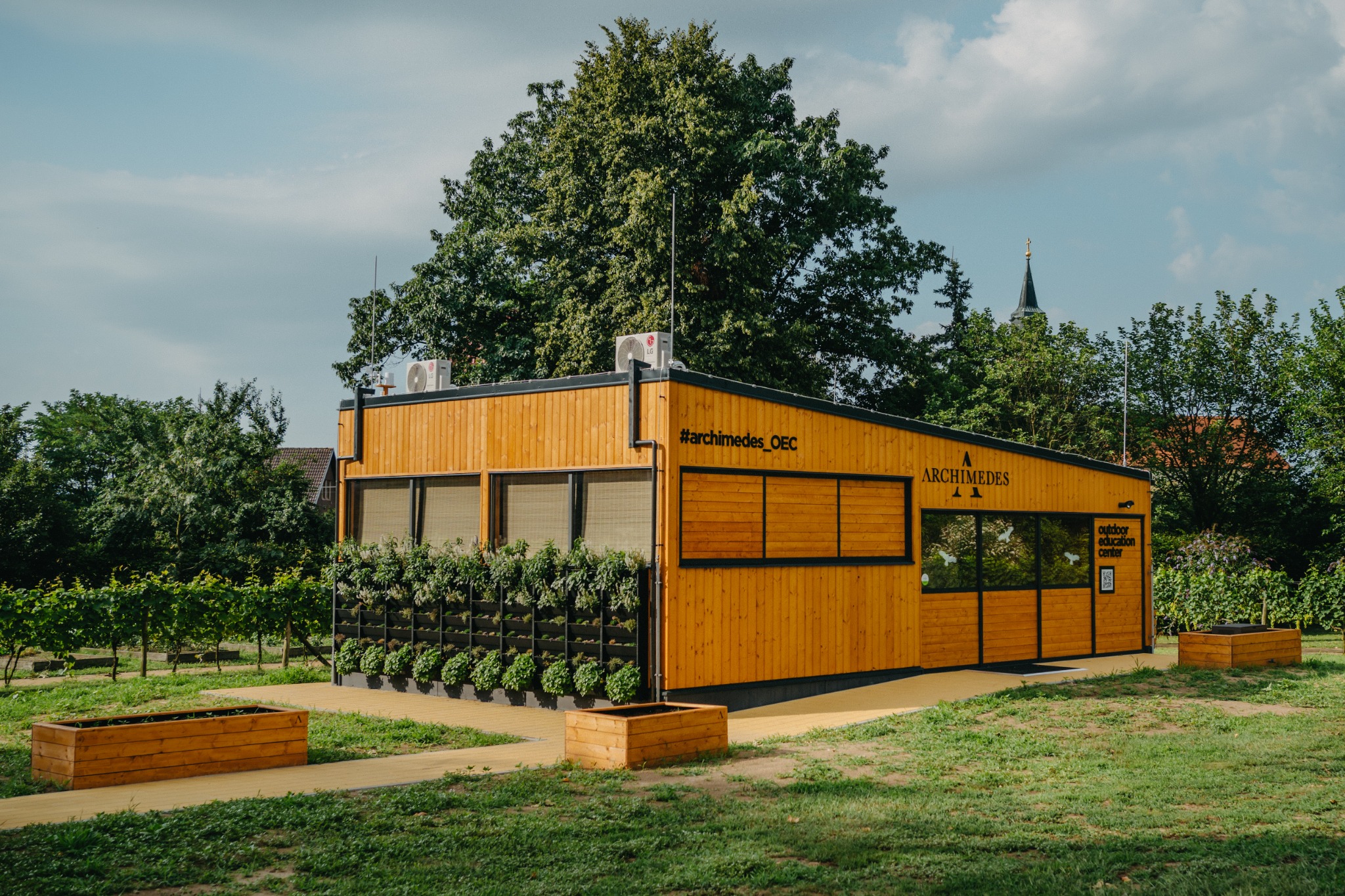 Celkový pohled na celou skutečnou venkovní učebnu ARCHIMEDES® se zelenou stěnou a záhony